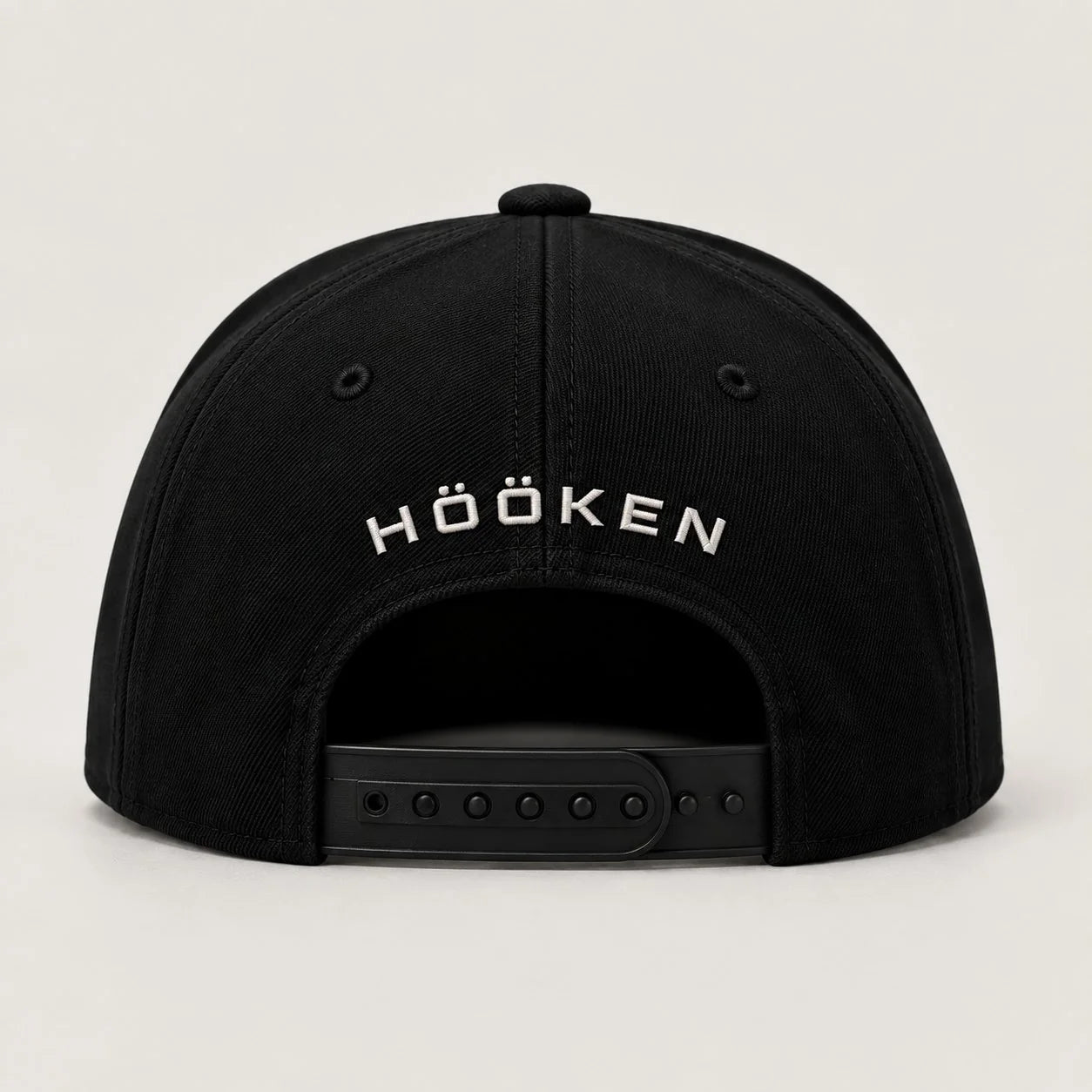 Svart Hööken-keps med HÖÖKEN-text ovanför spännet.